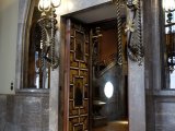 The painted central hall doors with iron and brass lamps