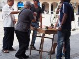 Street gambling (dice) on a very uneven table!